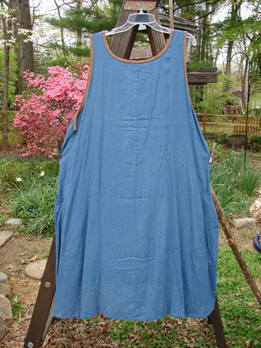 Barclay Linen Contrast Pocket Jumper Unpainted Deep Teal Size 2 displayed on a wooden stand, highlighting its flowing shape, rounded neckline, and front wrap drop pockets.