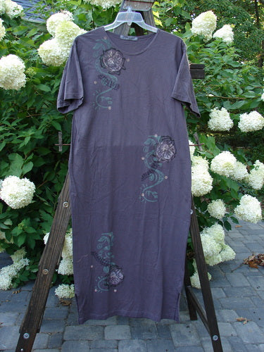 1996 Long Tea Dress Curl Rose Violet Field Size 1 displayed on a wooden stand, featuring a scooped neckline, straighter shape, tapered bottom with side vents, and vibrant flower theme.