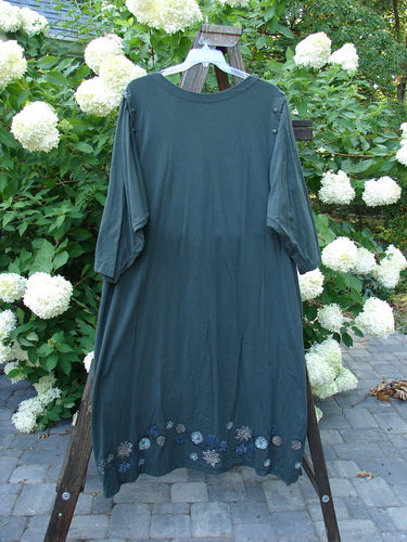 1994 Convertible Coat Spin Flower Deep Moss OSFA displayed on a mannequin outdoors, showcasing its button-on sleeves, upward scooped hemline, and unique painted flower theme.