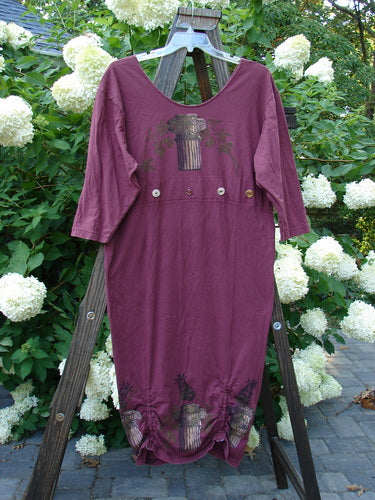 Image alt text: 1993 Deep Neck Button Dress Woodberry Roman Strings OSFA - A purple dress on a wooden stand, featuring a deep and wide neckline, lower tapering shape, and three vertical bottom interior draw cords.