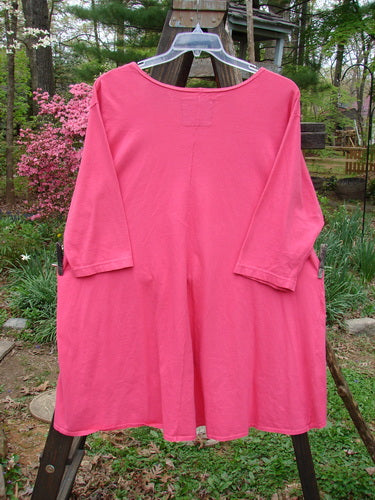 Barclay High Low Top Unpainted Flamingo Size 2, displayed on a mannequin, showcasing its A-line rounded hem, feminine neckline, and longer three-quarter inch sleeves, emphasizing its full bottom swing design.