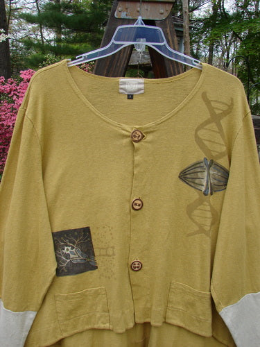 2000 Cotton Hemp Philos Jacket Biology Gold Size 2 featuring a DNA design, scooped varying hemline, horizontal panels, contrasting sleeves, two pockets, and rear flounce in a soft knit fabric.