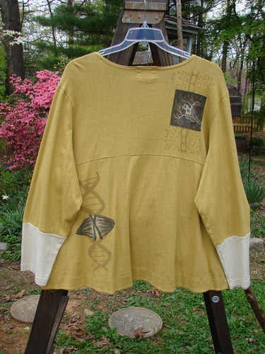 A close-up of a yellow Philos Jacket with contrasting sleeves and a biology-themed paint design.