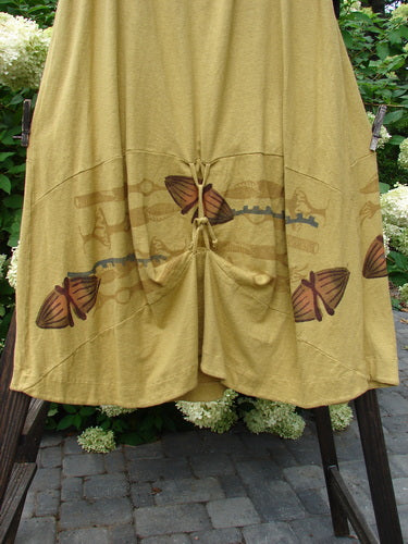 A yellow skirt with butterfly prints from the 2000 Resort Collection, featuring a full elastic waistband, sectional horizontal panels, and creative adjustable loops.