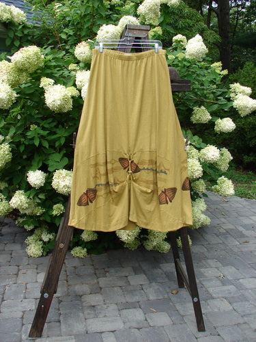 2000 Cotton Hemp Shade Skirt Bio Cell Gold Size 2 on a rack, showcasing its full elastic waistband, sectional horizontal panels, and varying hemline for creative adjustments.
