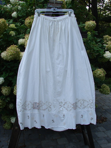 Barclay Linen Duet Skirt Tiny Floral White Size 2 displayed on a hanger, showcasing its bell shape, sectional panels, and floral-themed embroidery.