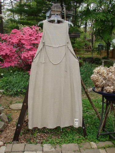 1998 Linen Knit Wrap Dress Unpainted Natural Size 1: A dress on a rack, featuring a flowing linen knit, rounded rolled neckline, and slender drape.