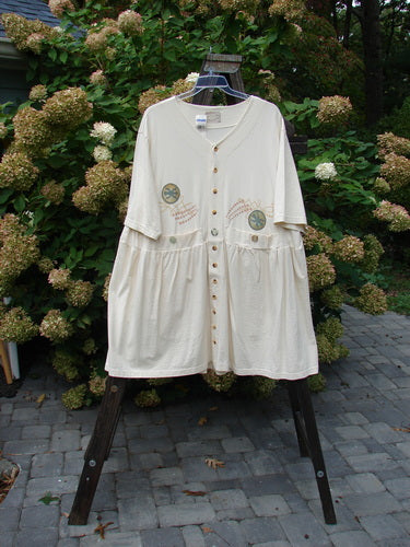 1999 NWT Vintage Button Dress Stone Skip Natural Size 2, displayed on a rack, showcasing its baby doll style with 11 front buttons, 3 waist buttons, pleats, and two front pockets.