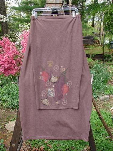 Barclay Button Panel Skirt Vegetable Sepia Size 2: A towel on a clothes rack with a purple shirt featuring vegetables. Close-up of pink flowers and a cloth.