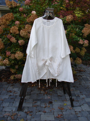 Barclay Linen Venetian High Vent Tunic Dress Tall Bud White Size 2 displayed on a hanger, showcasing its flowing A-line shape, softly squared neckline, and intricate S-shaped seams.