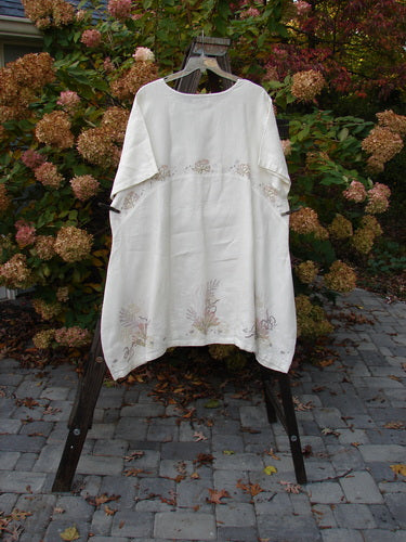 Barclay Linen Urchin Tunic Dress Undersea White Size 2 displayed on a hanger, showcasing a rounded neckline, A-line shape, downward curved empire waist seam, wide short sleeves, and painted undersea theme.