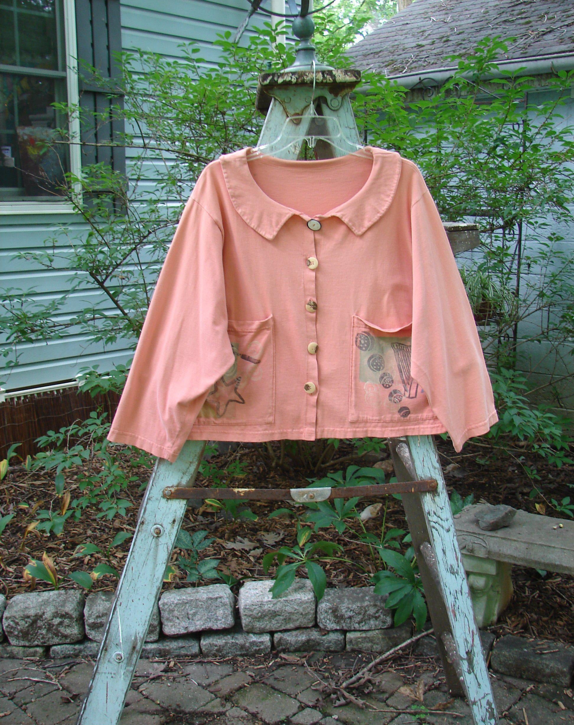 1994 Box Pocket Jacket Reef Harp Star Size 1: A pink shirt on a ladder with a pocket. Vintage Collectible from the Summer Collection of 1994. Made from Medium Weight Cotton. Features include a unique collar, big front pockets, and original buttons. Bust 50, Waist 50, Hips 50, Length 22.