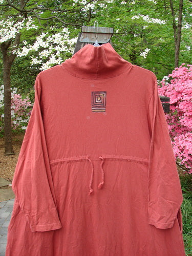 1995 Omega Dress Triple Path Red Glaze Size 1, featuring a heavy ribbed turtleneck, drop shoulders, deep side pockets, and a drawcord backline, showcased with a generous A-line flare.