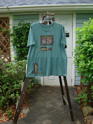 1993 Short Sleeved Tee with tractor design on a rack. Vintage Grey Green color. One Size Fits All. Bust 50, Waist 50. Length 30 inches.