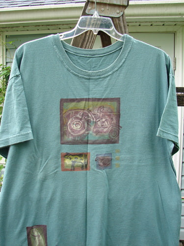 1993 Short Sleeved Tee featuring a picture of a farm and tractor theme paint on a grey green t-shirt. Boxy shape, shorter sleeves, ribbed neckline, and Blue Fish patch. Bust 50, waist 50, length 30 inches.
