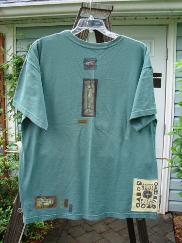 1993 Short Sleeved Tee with tractor graphic on a swinger. Boxy shape, shorter sleeves, ribbed neckline. Vintage Blue Fish patch. Bust 50, waist 50, length 30.