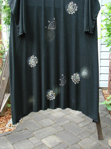 1995 Acetate Lycra Celebration Dress Celtic Turn Onyx Size 2, featuring a sweeping lettuce-edged hemline, slightly longer sleeves, and a thin rounded neckline, displayed against a stone floor.