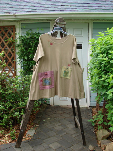 1997 Montage Dress Space Odyssey Wheat Size 2, featuring an A-line shape, offset oversized front pockets with vintage buttons, and a signature Blue Fish patch, displayed on a hanger.