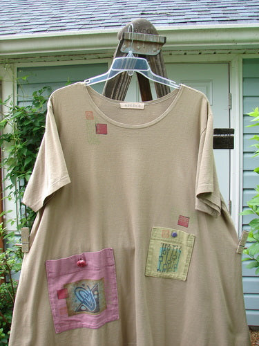 1997 Montage Dress Space Odyssey Wheat Size 2 with painted pockets, vintage buttons, and a rounded neckline. Features a swingy A-line shape and signature Blue Fish patch, made from organic cotton.