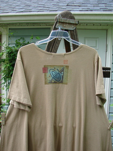 1997 Montage Dress Space Odyssey Wheat Size 2 displayed on a hanger, featuring a swingy A-line shape, oversized front painted pockets with vintage buttons, and a rounded neckline.