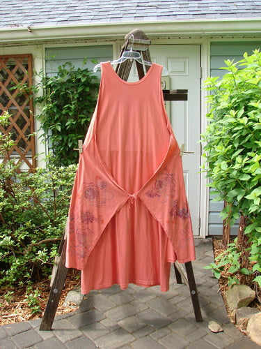 Barclay Side Panel Jumper Floral Tangerine Altered Size 2 displayed on a rack, showcasing deep neckline, arm openings, and dramatic hemline with floral pattern.