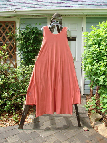 Barclay Side Panel Jumper Floral Tangerine Altered Size 2 displayed on a clothes rack with detailed side panels, deep arm openings, and a dramatic varying hemline.