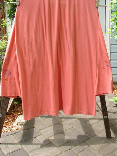 A Barclay Side Panel Jumper Floral Tangerine Altered Size 2 displayed on a clothes rack, showcasing deep arm openings and varying hemline with superior floral paint.