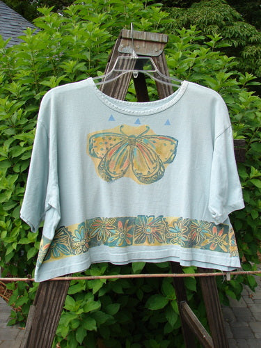 1992 Short Sleeved Crop Tee with butterfly and daisy design on blue fabric.