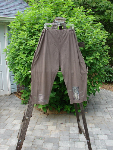 1994 Wanderer's Pant Spirit Woman Humus Size 1: A pair of brown pants on a rack. Crop length with a widening rounded hip. Full drawstring waistline and side entry front pockets. Made from medium weight cotton jersey.