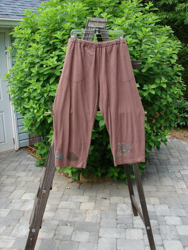 Image: A pair of pants on a rack, with a vintage travel theme paint and a slightly tapered inseam. Dusty rose color. Size 1.

Alt text: Vintage 1993 Resort Crossroad Pant in Dusty Rose, Size 1, with travel-themed paint and tapered inseam.