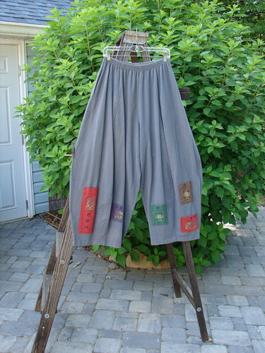1997 Nuts and Bolts Pant Window Granite Size 1: A pair of pants with patchwork pockets on a rack. Perfect for keeping your little nuts, bolts, and trinkets!