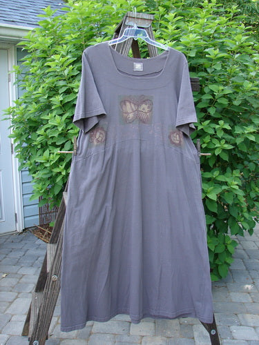 1999 Windmill Dress Butterfly Raven Size 2 on a clothes rack, featuring a square neckline, flared hemline, nature-themed design, and deep side pockets, showcasing vintage Blue Fish Clothing’s unique style.