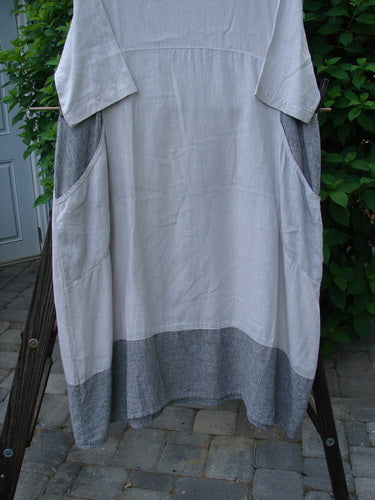 Barclay Linen Stripe Tulip Dress Unpainted Pebble Black Size 1 displayed on a clothes rack, showcasing its medium scoop neckline, three-quarter sleeves, and tulip bottom flare with pinstripe accents.