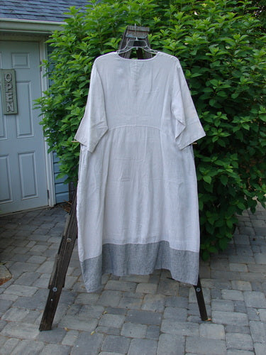 Barclay Linen Stripe Tulip Dress Unpainted Pebble Black Size 1 displayed on a clothes hanger outdoors. Features three-quarter sleeves, scoop neckline, and tulip bottom flare.