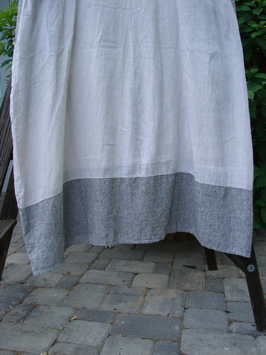 Barclay Linen Stripe Tulip Dress Unpainted Pebble Black Size 1 displayed on a rack with distinct white and grey towel nearby.