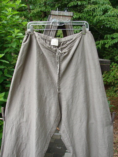 A pair of 2000 Shaunting Silk Slant Drawcord Pants in Cement, size 2. Rear elastic waistband with drawcord front. Wider hips and lowers. Classic Transitions theme paint. Lengthier inseam and fall. Waist relaxed 26-56, extended 56. Hips 56. Inseam 26. Length 40.