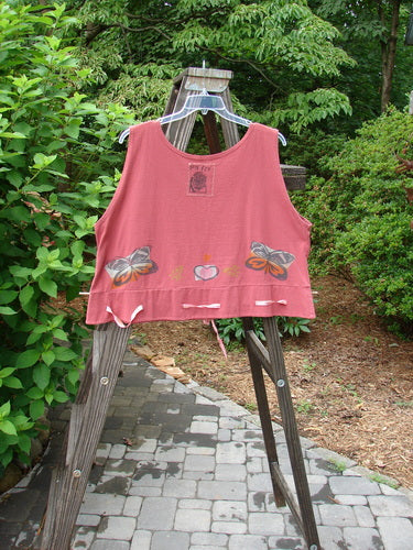 1992 Camisette Top Butterfly Sienna OSFA on a wooden rack, showcasing the scooped neckline, swingy hemline with button holes, and vintage butterfly and heart design.