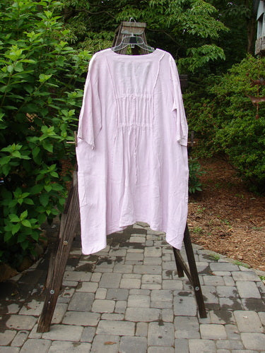 Barclay Linen Double Tie Back Jacket Sprig Pink Cloud Size 0 displayed on a rack, featuring a deep V neckline, A-line sweep, vertical stitchery, front drop pockets, and varying hemline.