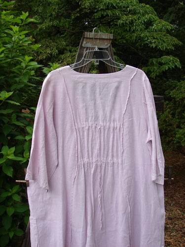 Barclay Linen Double Tie Back Jacket Sprig Pink Cloud Size 0 displayed on a wooden swing, featuring a deep V neckline, A-line sweep, exterior vertical stitchery, and drop flop pockets.