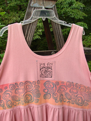 1992 Peplum Top Rose Border Pink Clover OSFA displayed on a wooden stand, showcasing its vintage baby doll style with a yoke waist seam, rounded neckline, and a signature Blue Fish patch.