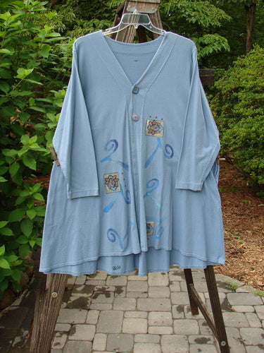 1997 Mask Jacket Windy Floral Peacock Size 1 displayed on a wooden swing against a stone surface, showcasing bell shape, two-button closure, deep side pockets, and a rounded swing hemline.