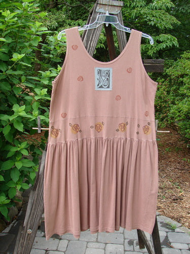 1993 Tier Dress Water Lilly Dried Rose Size 2: A dress on a clothesline, featuring a pink dress with a flower design. Perfect condition, made from cotton. Lovely banded drop waistline, super bottom flounce, and sweet baby doll pleats. Bust 50, waist 52, hips 60, length 36 inches.