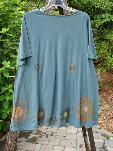 1993 Vagabond Dress Metallic Pinwheel Grey Green OSFA: Medium weight cotton dress featuring a rolled V-shaped neckline, A-line shape with V inserts, and a sweeping lower section with a metallic pinwheel theme.