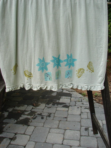1991 Short Milkmaid Dress Sun Star Sage OSFA: A white towel with blue flowers on it, showcasing the unique bell shape, dropped waistband, and laced neck hem and sleeve line.