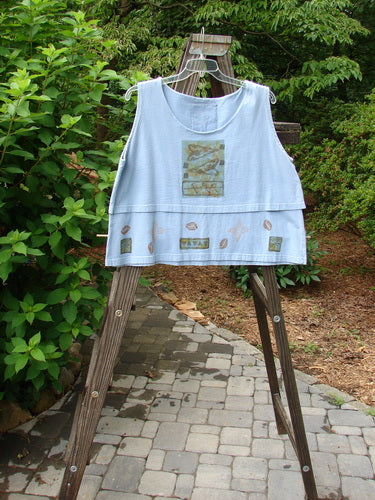 1993 Parallel Top Tiny Heart Sky OSFA displayed on a rack, featuring a crop A-line cut, wide rounded neckline, and double-layered bodice with a blue fish patch on the back.