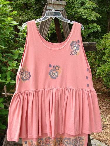 1992 Peplum Dress Floral Border Pink Clover OSFA displayed on a swing, showcasing its empire waist, oversized buttons, gathered lower, and hand-dyed silk ribbon accents.