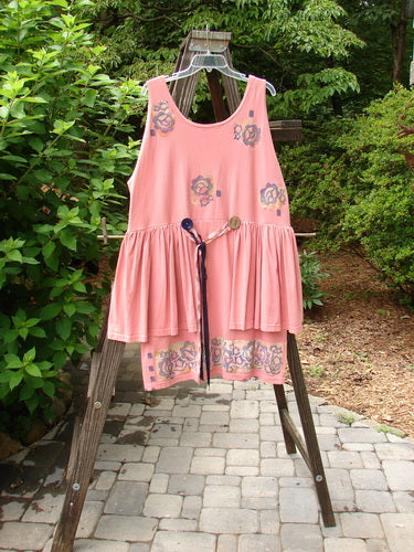 1992 Peplum Dress Floral Border Pink Clover OSFA with oversized buttons, empire waist, gathered lower, and hand-dyed silk ribbon, displayed on a swing outdoors.