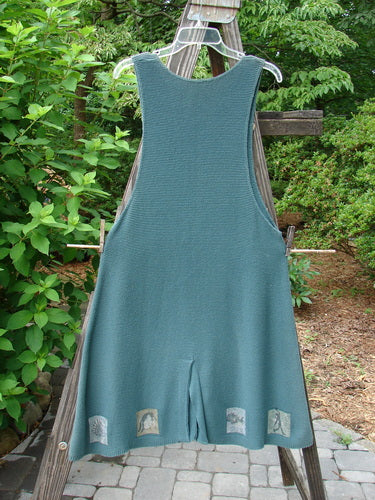1994 Vent Vest Sweater Jumper Mixed Theme Lichen OSFA: A blue overalls on a clothes rack, part of the Spring Collection of 1994. Features include a slenderizing A-line shape, rear walking vent, and detailed hemline whimsical paint. Perfect for smaller fishers with a generous hip flair. Bust 40, Waist 44, Hips 50, Hem Circumference 72, Length 38.