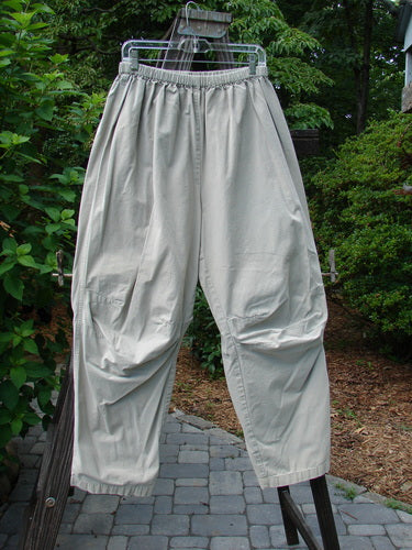 2000 Parachute Trekker Pant Unpainted Sand Size 2: A pair of pants on a clothes rack, made from sturdy cotton fabric with additional knee fabric. Tapering lowers and a full elastic waistline.