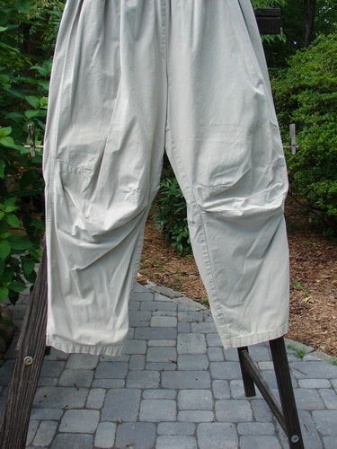 2000 Parachute Trekker Pant Unpainted Sand Size 2: A pair of white pants on a rack, made from medium weight cotton parachute. Features include additional knee fabric, slightly tapering lowers, and a full elastic waistline.